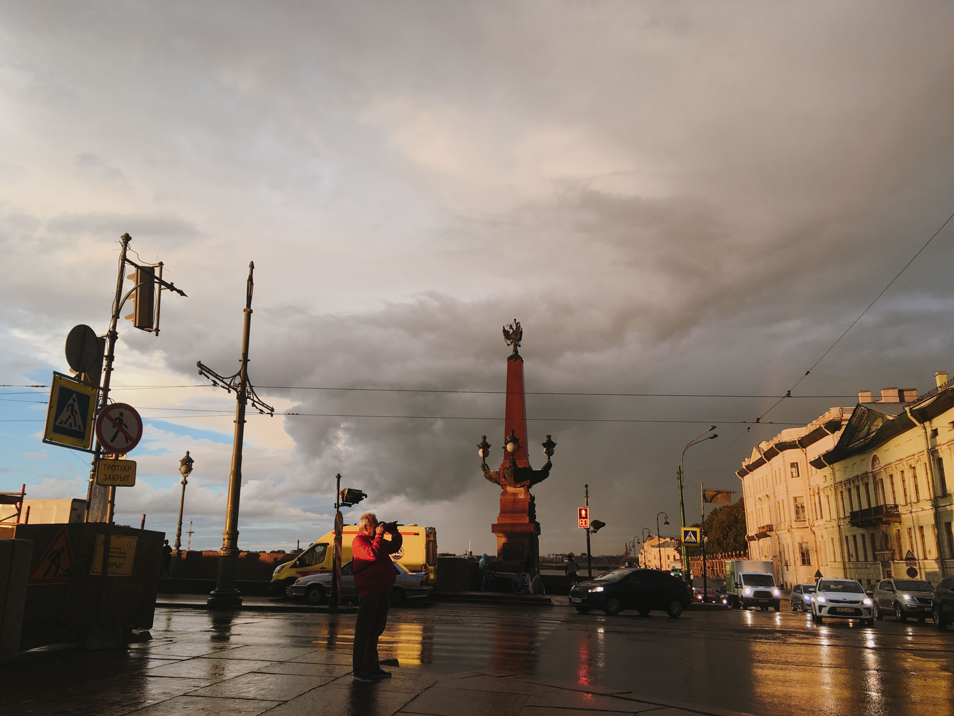 Фотограф делает снимок радуги над Санкт-Петербургом